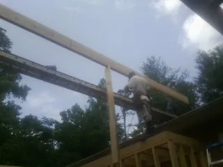 Carpenter setting a ridge beam over a new addition frame — Ice Dam Removal by Roofing Brothers in Slate Run