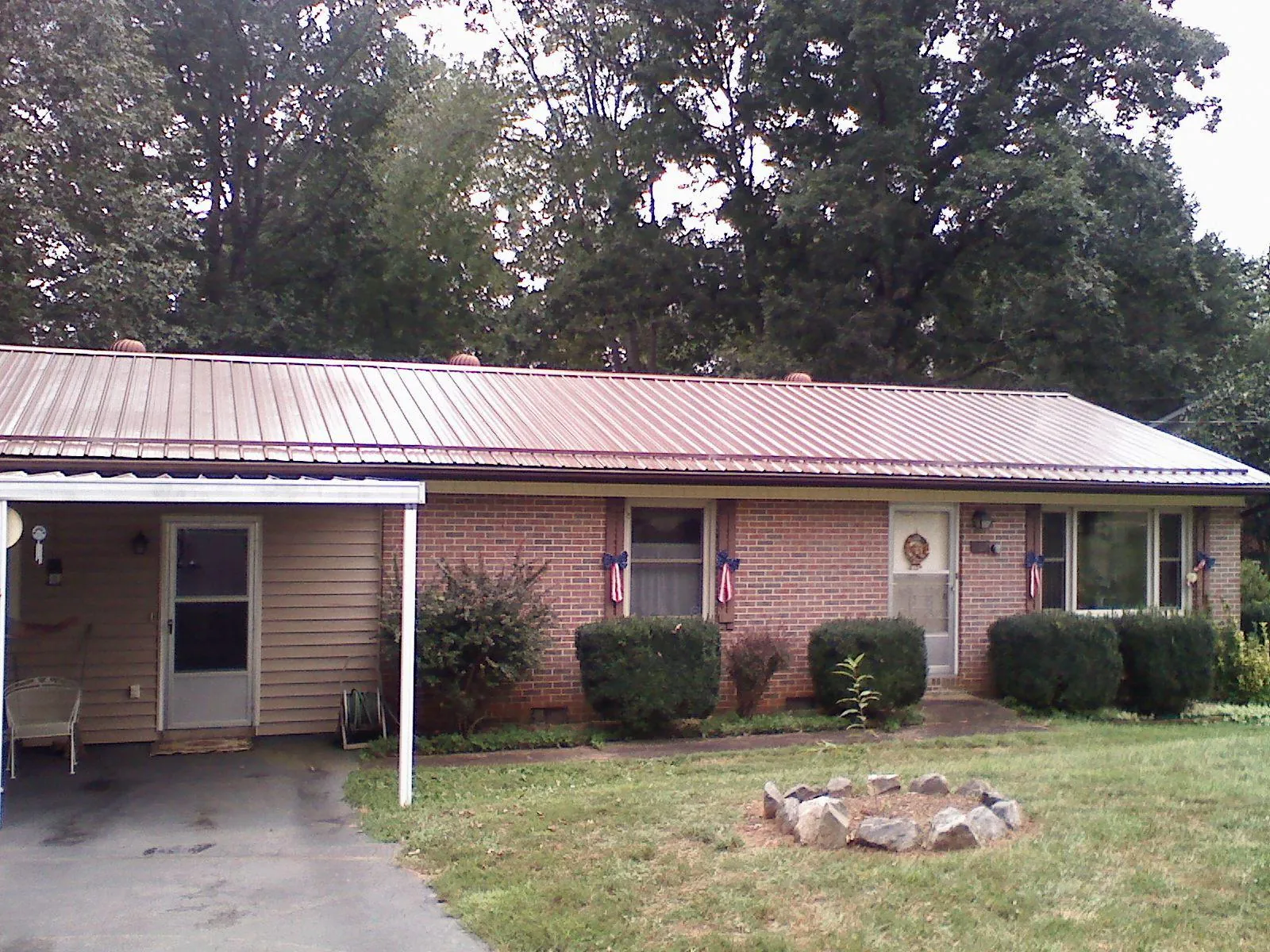 Bronze metal roof and carport on a brick ranch home — Roof Repair work by our crew in Slate Run